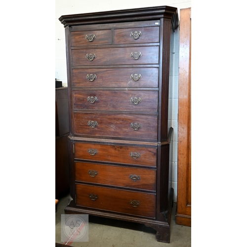 123 - A faux-fronted mahogany chest-on-chest wardrobe, the full length door mimicking stacked drawers encl... 