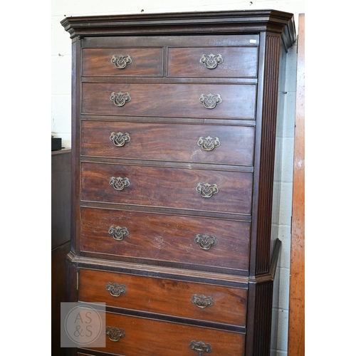 123 - A faux-fronted mahogany chest-on-chest wardrobe, the full length door mimicking stacked drawers encl... 