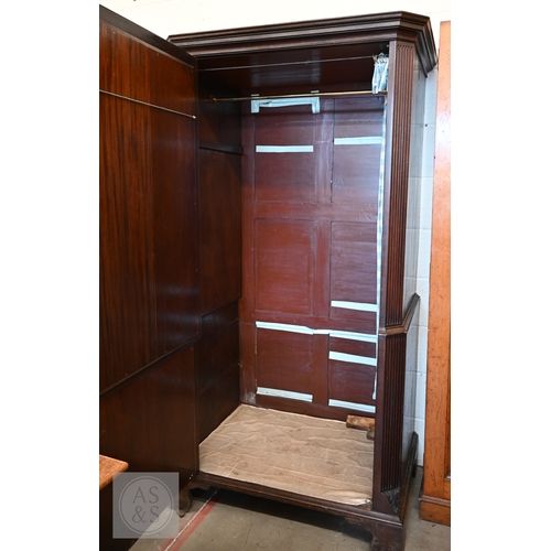 123 - A faux-fronted mahogany chest-on-chest wardrobe, the full length door mimicking stacked drawers encl... 