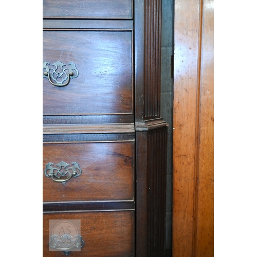 123 - A faux-fronted mahogany chest-on-chest wardrobe, the full length door mimicking stacked drawers encl... 