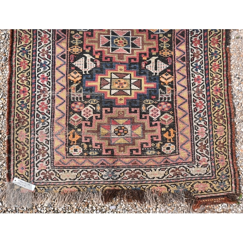 55 - An antique Caucasian Akstafa runner with vertically stacked eight-point star medallions on a dark fi... 
