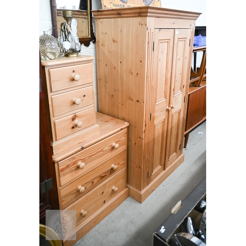 121 - A modern waxed pine child's bedroom suite, comprising small wardrobe with full length panelled doors... 