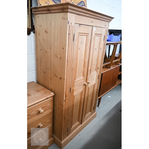 121 - A modern waxed pine child's bedroom suite, comprising small wardrobe with full length panelled doors... 