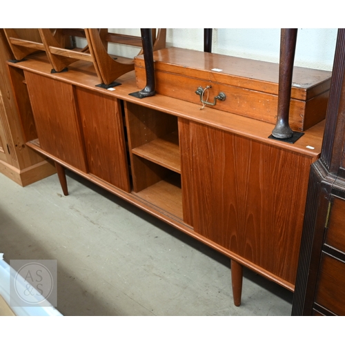 122 - A Mid-Century Danish teak sideboard, four sliding doors enclosing shelves and drawers, raised on tap... 