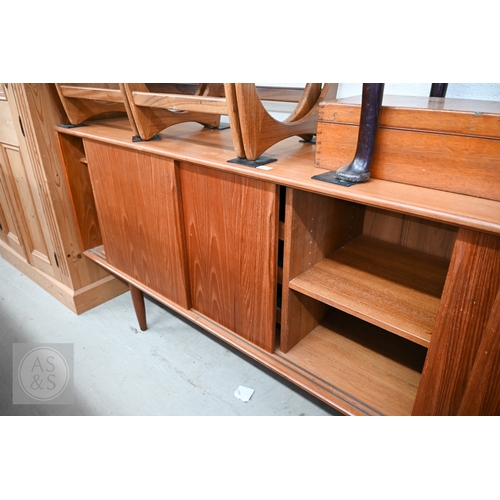122 - A Mid-Century Danish teak sideboard, four sliding doors enclosing shelves and drawers, raised on tap... 