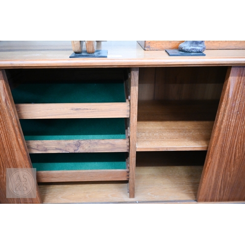122 - A Mid-Century Danish teak sideboard, four sliding doors enclosing shelves and drawers, raised on tap... 