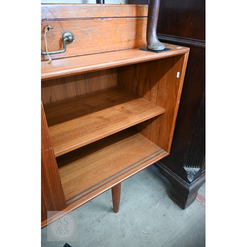 122 - A Mid-Century Danish teak sideboard, four sliding doors enclosing shelves and drawers, raised on tap... 