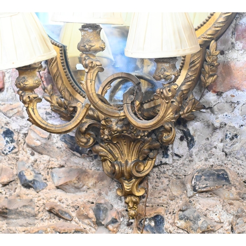17 - An antique giltwood and gesso girandole mirror in the rococo style, of trefoil form surmounted by a ... 
