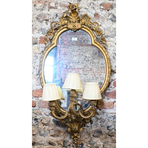 17 - An antique giltwood and gesso girandole mirror in the rococo style, of trefoil form surmounted by a ... 