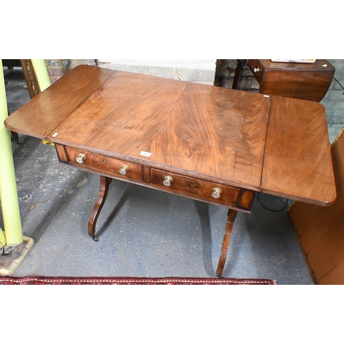 25 - A Victorian mahogany two drawer sofa table with drop ends raised on trestle ands and brass castors