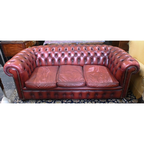 26 - A Victorian style buttoned red-brown leather Chesterfield sofa with scroll arms