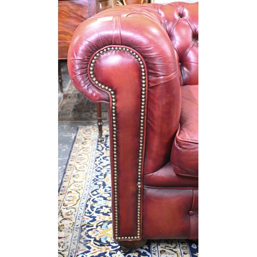 26 - A Victorian style buttoned red-brown leather Chesterfield sofa with scroll arms