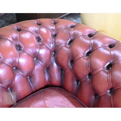 26 - A Victorian style buttoned red-brown leather Chesterfield sofa with scroll arms