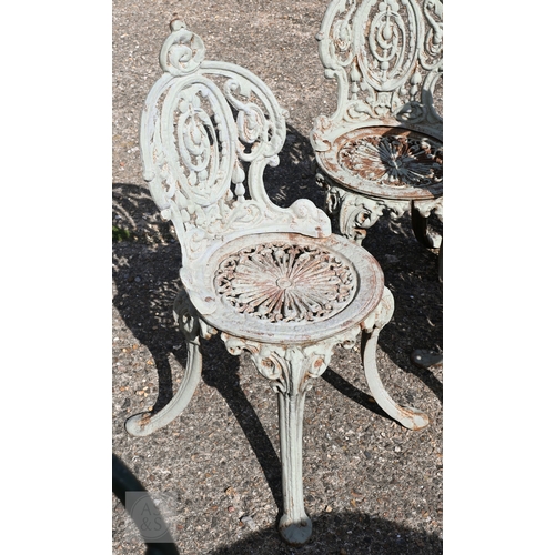 31 - A set of four Victorian style heavy cast terrace chairs with fan design seats and oval backs, in wea... 