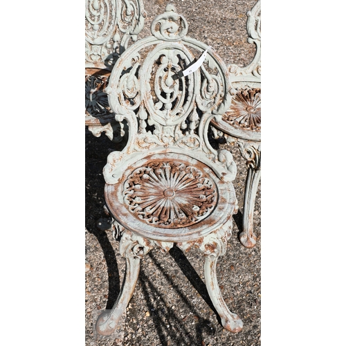 31 - A set of four Victorian style heavy cast terrace chairs with fan design seats and oval backs, in wea... 