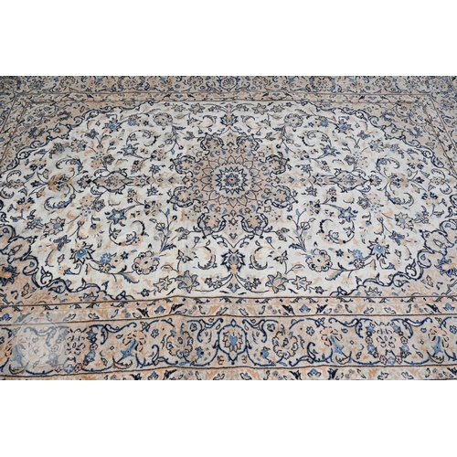 464 - A central Persian Kashan carpet, the ivory ground with trailing flowering vines in blues, 313 cm x 2... 