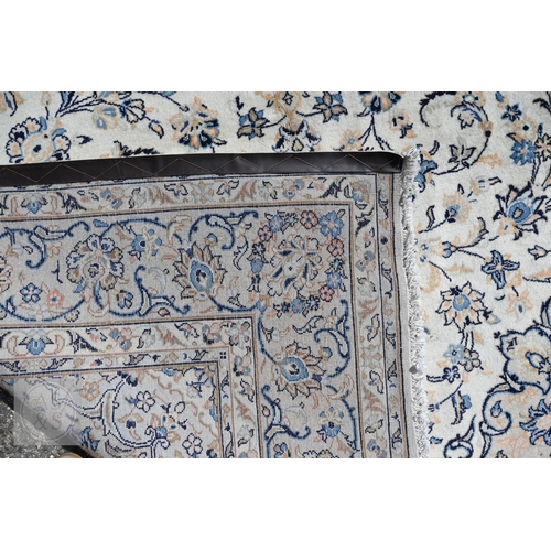 464 - A central Persian Kashan carpet, the ivory ground with trailing flowering vines in blues, 313 cm x 2... 
