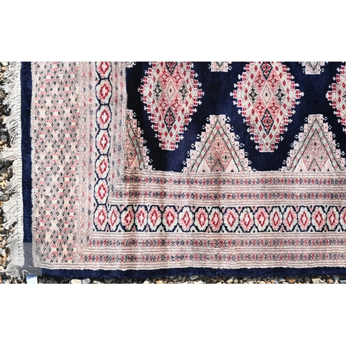 54 - Two Indo-Persian part silk Kashan rugs, traditional floral designs on blue-black ground, mid-20th ce... 