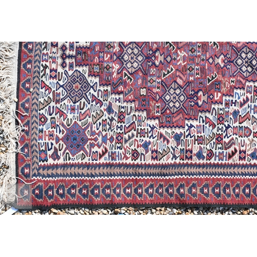 57 - A Persian Kashqai kelim, the camel ground with geometric designs, 202 cm x 106 cm