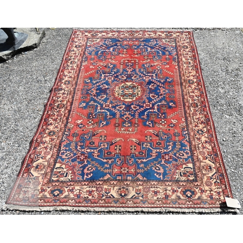 466 - A North West Persian Tafresh rug, the red ground centred by a blue floral medallion, 200 cm x 130 cm