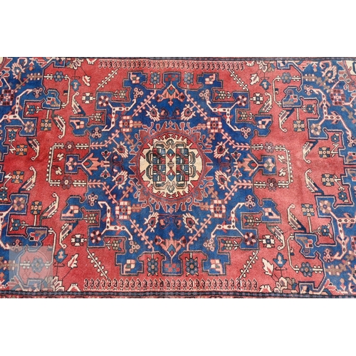 466 - A North West Persian Tafresh rug, the red ground centred by a blue floral medallion, 200 cm x 130 cm