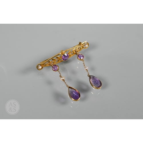 252 - An Edwardian yellow gold brooch set amethyst and seed pearls, with two chain linked amethyst and see... 