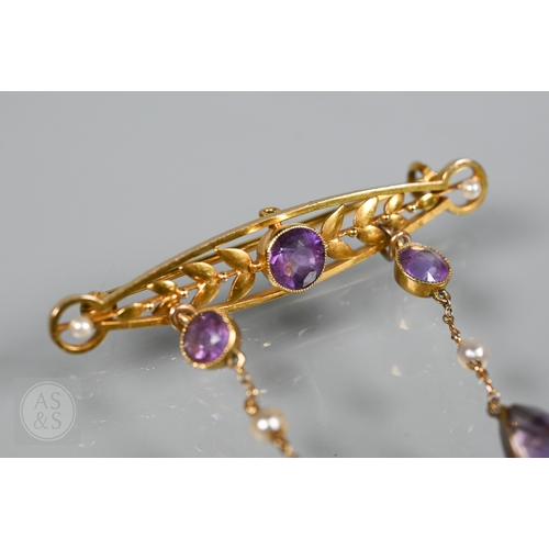 252 - An Edwardian yellow gold brooch set amethyst and seed pearls, with two chain linked amethyst and see... 