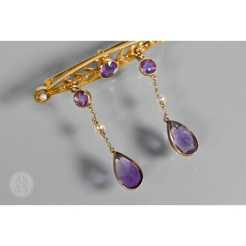 252 - An Edwardian yellow gold brooch set amethyst and seed pearls, with two chain linked amethyst and see... 