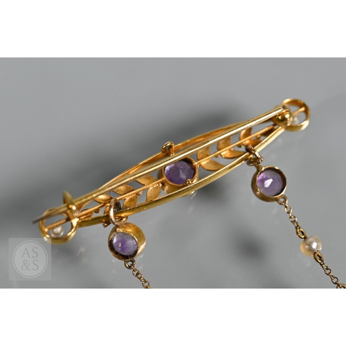 252 - An Edwardian yellow gold brooch set amethyst and seed pearls, with two chain linked amethyst and see... 