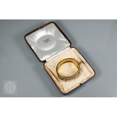 253 - A Victorian bloomed gold oval half-hinged bangle, the frontispiece set with five squares of four see... 
