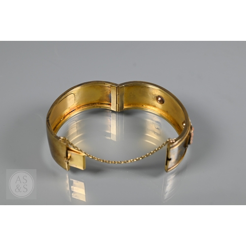 253 - A Victorian bloomed gold oval half-hinged bangle, the frontispiece set with five squares of four see... 