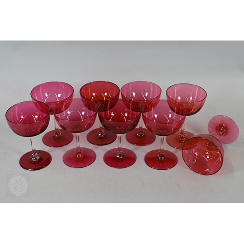 469 - A set of nine 19th Century cranberry glass champagne saucers with clear stems and ground-out pontil ... 