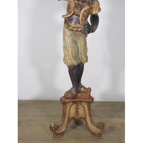 173 - A Venetian Blackamoor Torchere, the carved figure with an outstretched arm holding a candle stand, r... 