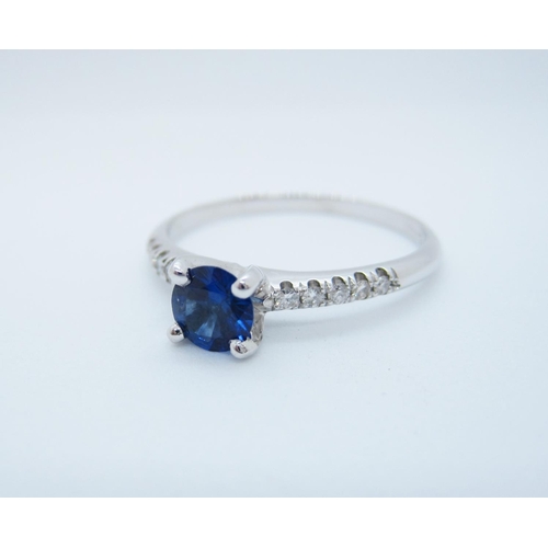 528 - A Sapphire and Diamond Ring claw-set round sapphire with brilliant-cut diamonds pave-set to shoulder... 