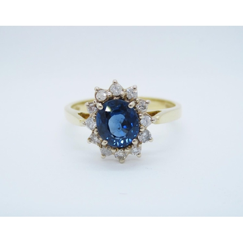 541 - A Sapphire and Diamond Cluster Ring claw-set oval-cut sapphire within frame of twelve brilliant-cut ... 