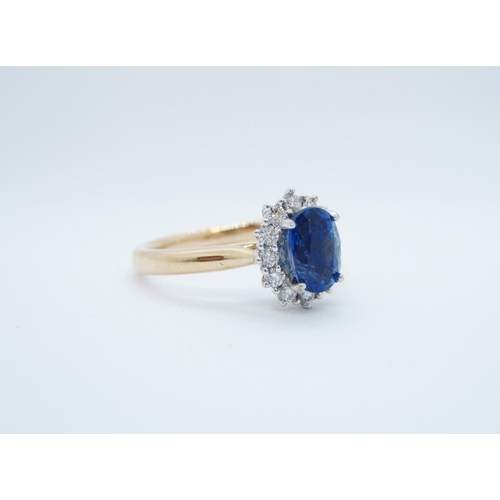 566 - A Sapphire and Diamond Cluster Ring, claw-set oval-cut sapphire, 1.25cts, within frame of brilliant-... 