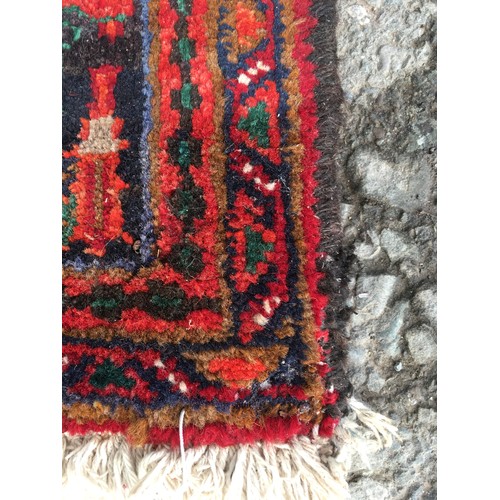 9 - A red ground Oriental woollen Rug with lotus flower central motif and stylised flower head border 9f... 