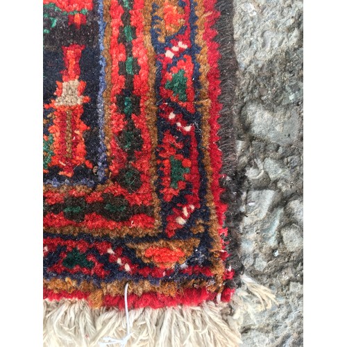 9 - A red ground Oriental woollen Rug with lotus flower central motif and stylised flower head border 9f... 