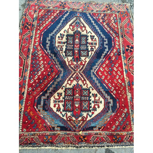 11 - A red ground woollen Rug 8ft 1in L x 5ft 7in W and another with blue waisted centre 5ft 9in L x 4ft ... 