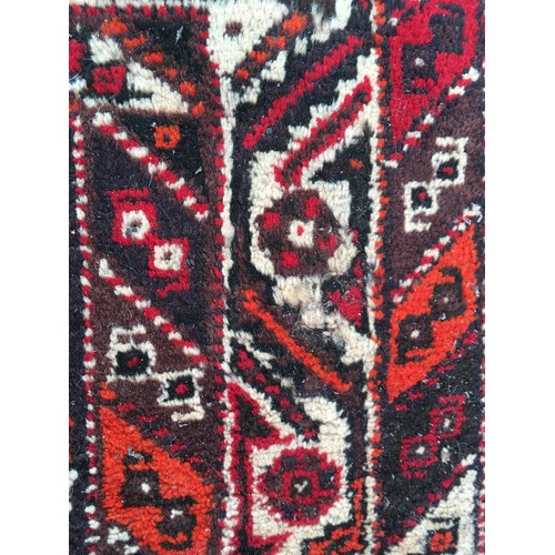 11 - A red ground woollen Rug 8ft 1in L x 5ft 7in W and another with blue waisted centre 5ft 9in L x 4ft ... 