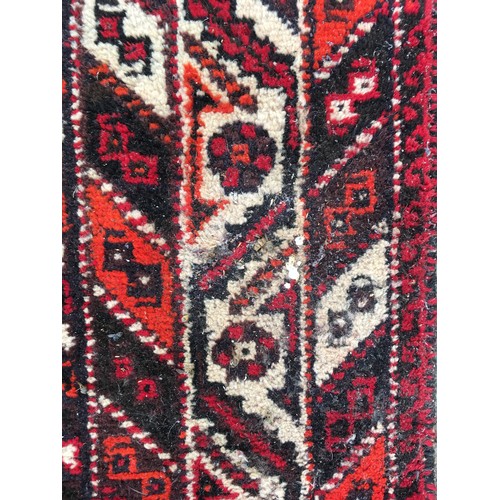 11 - A red ground woollen Rug 8ft 1in L x 5ft 7in W and another with blue waisted centre 5ft 9in L x 4ft ... 