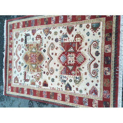 12 - A modern cream ground Rug with red border 6ft 4in L x 4ft 6in W and a red ground Runner 8ft 2in L x ... 