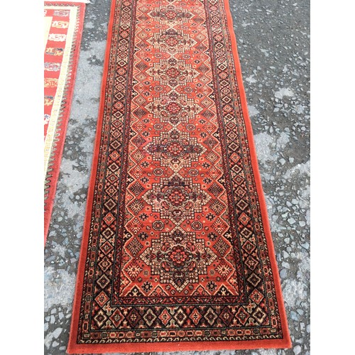 12 - A modern cream ground Rug with red border 6ft 4in L x 4ft 6in W and a red ground Runner 8ft 2in L x ... 