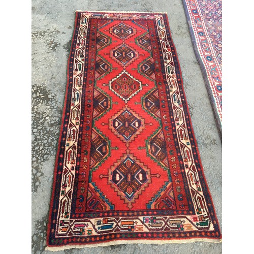 13 - A blue ground woollen Runner with floral decoration and red border 10ft L x3ft 8in W and a red groun... 