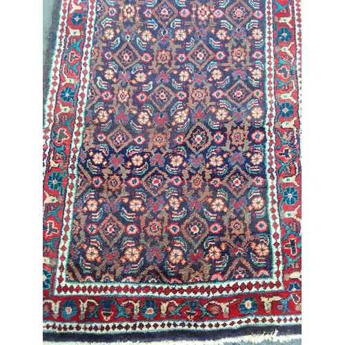 13 - A blue ground woollen Runner with floral decoration and red border 10ft L x3ft 8in W and a red groun... 