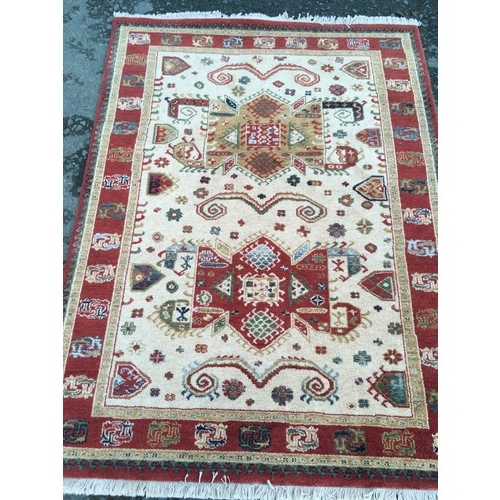 12 - A modern cream ground Rug with red border 6ft 4in L x 4ft 6in W and a red ground Runner 8ft 2in L x ... 