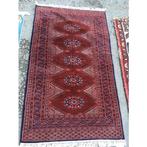 14 - A fine woven claret ground Rug with five central guls 5ft 4in L x 3ft W, a blue Chinese Rug 4ft 3in ... 