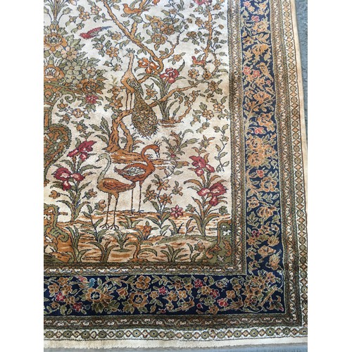 17 - A peach ground Carpet decorated with Tree of Life within blue floral design multiple border, approx ... 