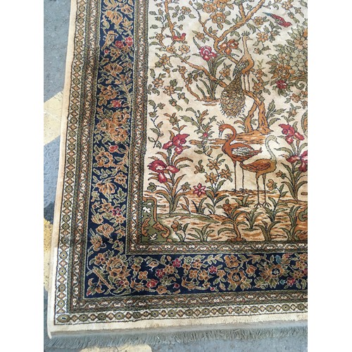 17 - A peach ground Carpet decorated with Tree of Life within blue floral design multiple border, approx ... 