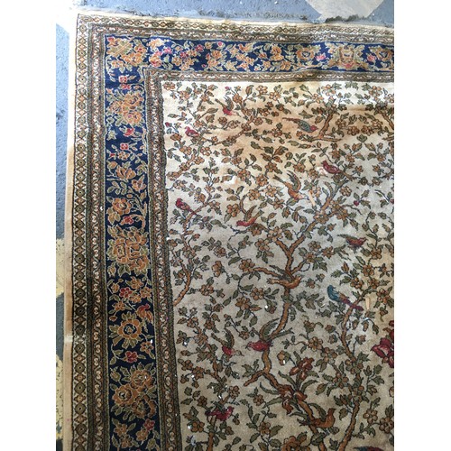 17 - A peach ground Carpet decorated with Tree of Life within blue floral design multiple border, approx ... 